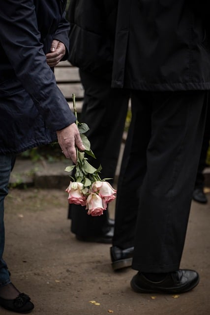 white and pink roses held at a funeral, black suit